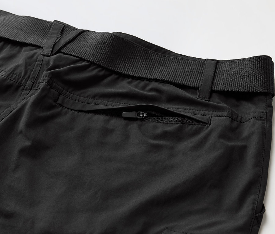 Gros plan sur un pantalon d’extérieur noir avec protection anti-moustiques et une ceinture noire.