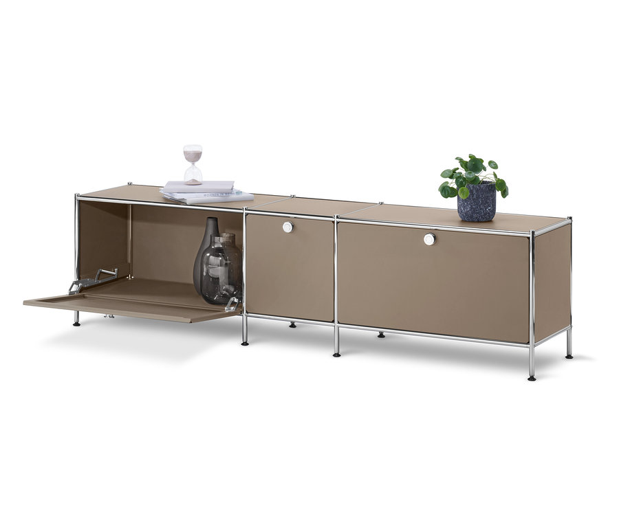 Meuble bas « CN3 » gris avec 3 abattants, dont un ouvert avec des vases à l'intérieur.