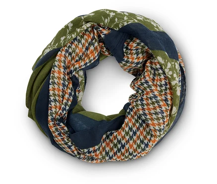Gros plan d'une écharpe tube avec différents motifs, notamment des motifs floraux, des pieds-de-poule et des blocs de couleur dans des tons de vert et de bleu.