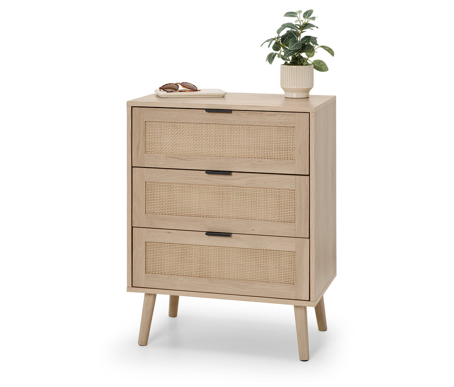 Commode avec trois tiroirs en rotin, sur laquelle reposent des lunettes de soleil et une petite plante.