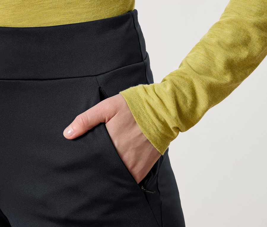 Main dans la poche d'un pantalon noir.