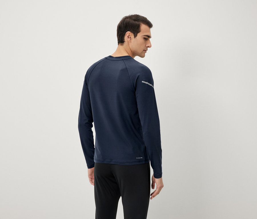 Homme vu de dos portant un t-shirt à manches longues bleu marine et un pantalon noir.