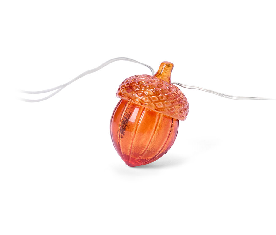 Gros plan d'une guirlande lumineuse en forme de gland orange sur fond blanc.