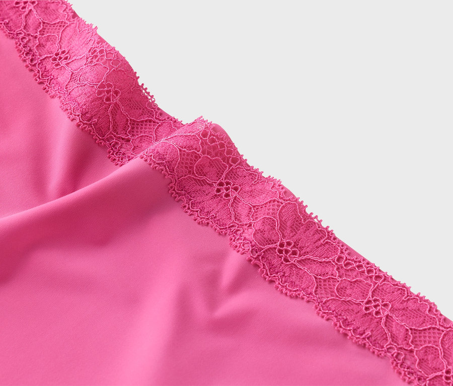 Gros plan sur un tissu rose avec de la dentelle rose.