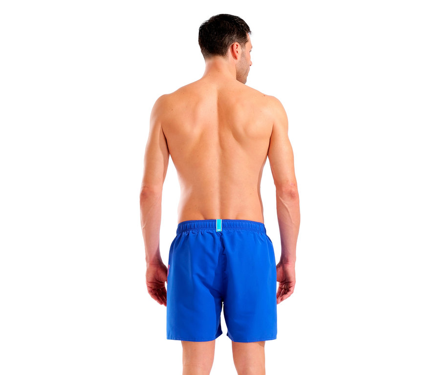 Vue de dos d'un homme portant un short de bain bleu sur fond blanc.