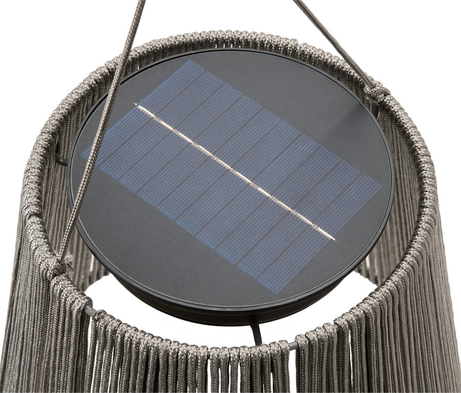 Gros plan d'une lampe solaire avec abat-jour tressé.