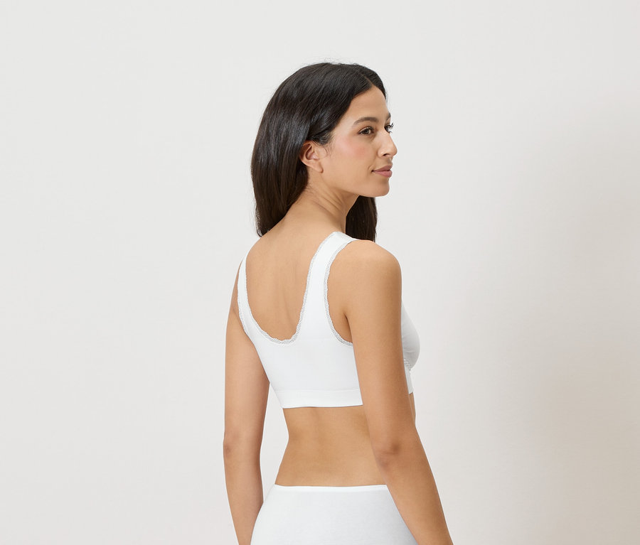 Femme portant un soutien-gorge blanc avec bordure en dentelle.