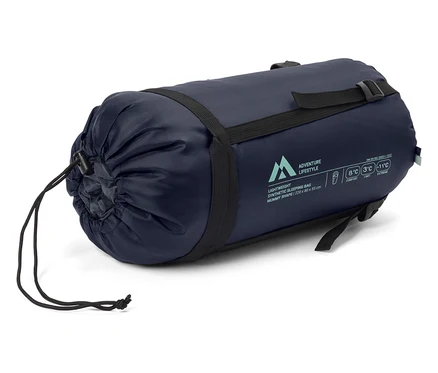 Un sac de couchage bleu marine est sanglé avec des sangles noires.