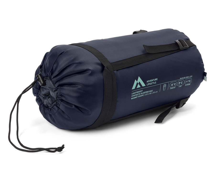 Un sac de couchage bleu marine est sanglé avec des sangles noires.