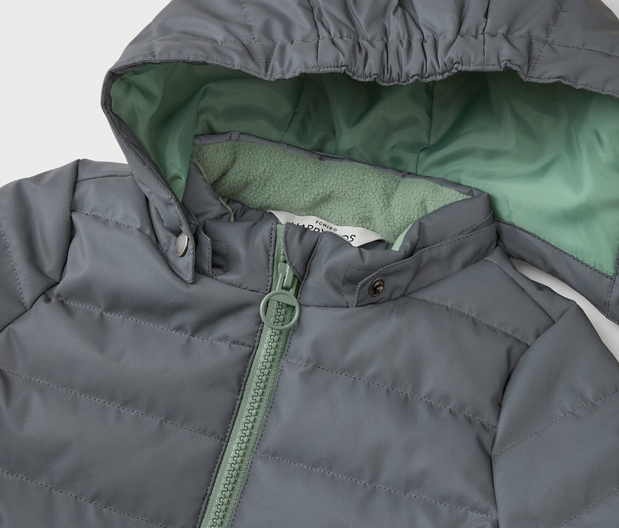 Gros plan d'une veste matelassée grise à capuche avec doublure et fermeture éclair vert menthe.