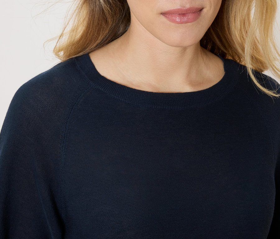 Gros plan d'une femme portant un pull bleu marine.