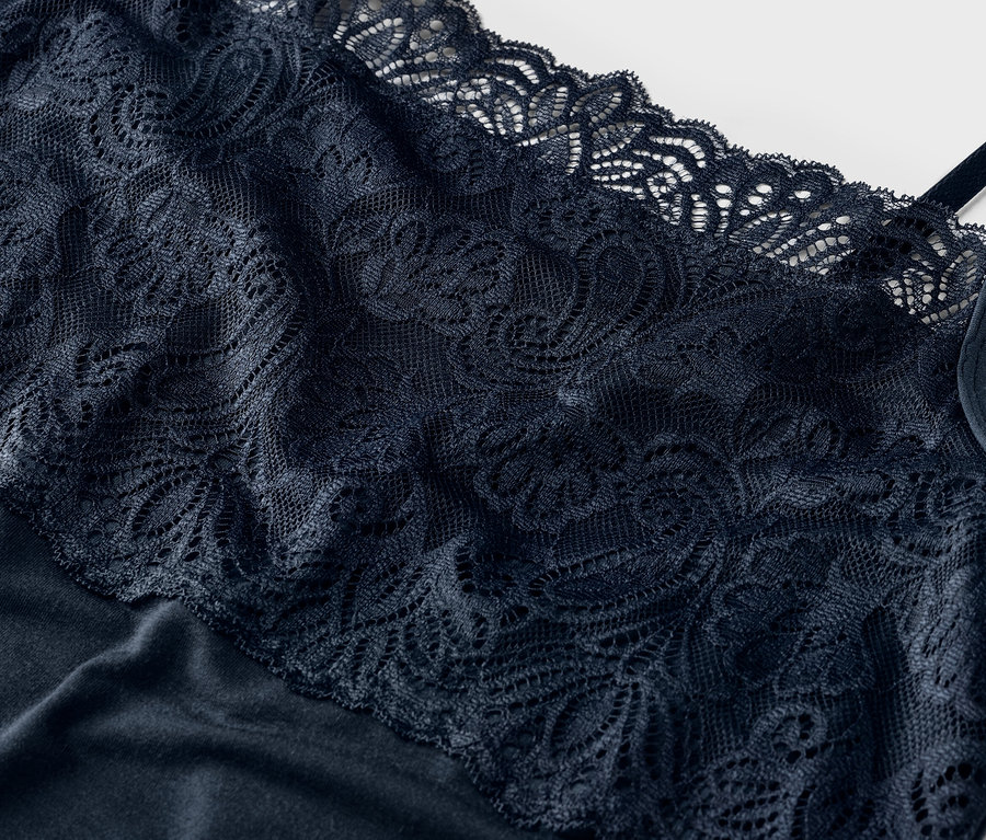 Vue détaillée d'un débardeur en dentelle bleu marine à fines bretelles.