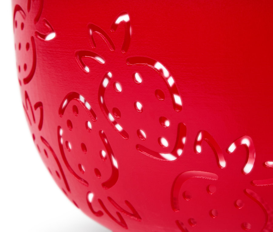 Gros plan d'une passoire de cuisine rouge avec un motif de fraises.
