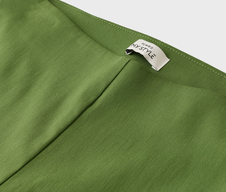 Gros plan sur un vêtement vert olive avec une étiquette portant l'inscription "TCHIBO MY STYLE".