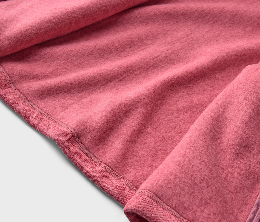 Gros plan d'un tissu polaire rose avec ourlet et fermeture éclair.