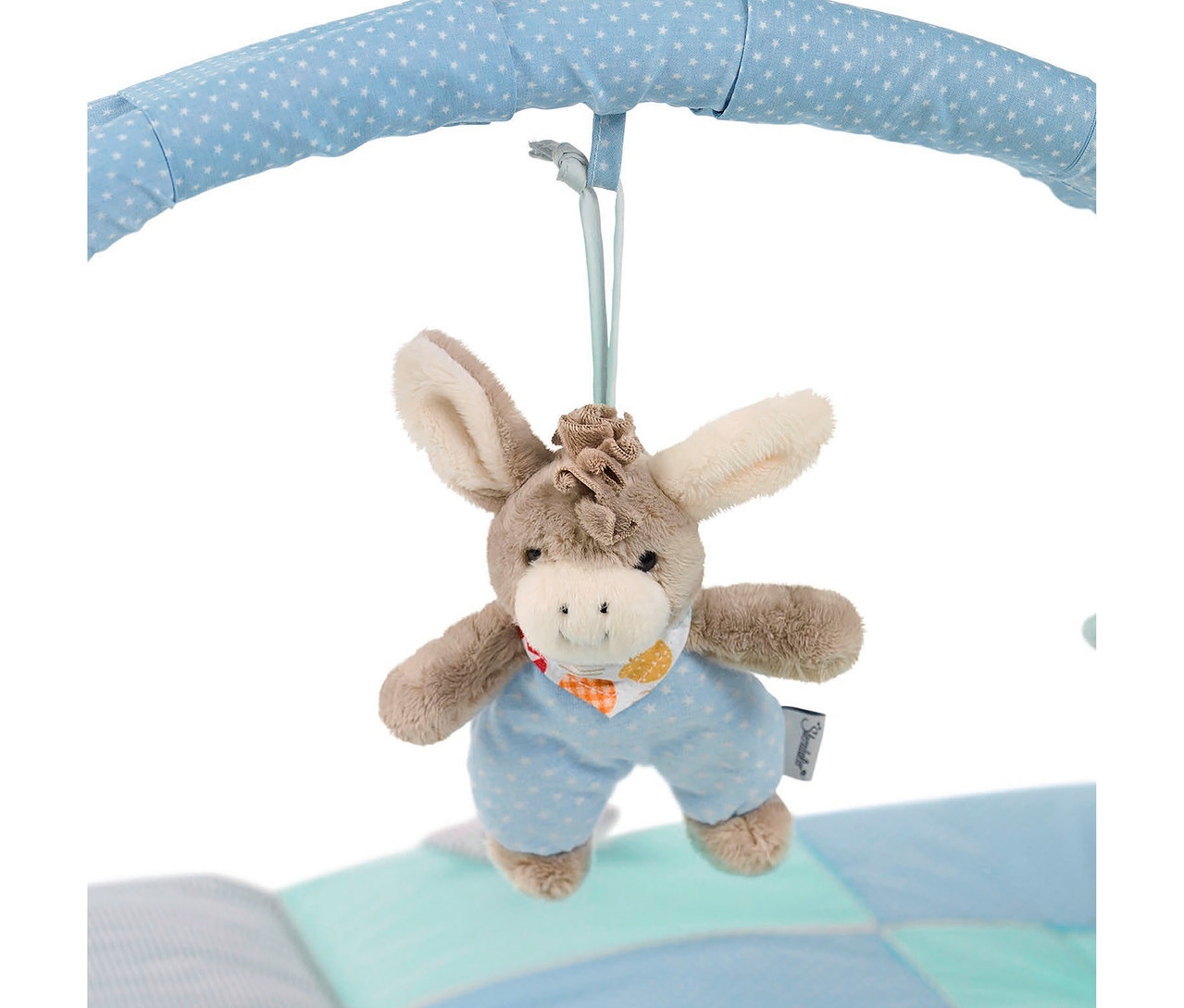 Jouet en peluche âne suspendu à une arche bleue à étoiles blanches. L'âne porte une salopette bleu clair et un bandana coloré. En dessous, on aperçoit un tapis matelassé dans des tons de bleu et de vert.