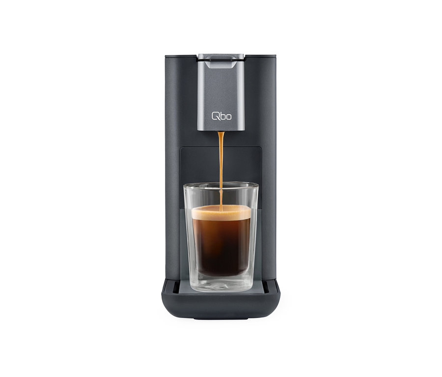 Café coulant d'une machine à café Qbo ESSENTIAL Dark Stone dans un verre.
