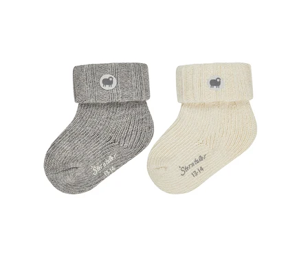 Deux chaussettes de bébé tricotées, une grise et une crème, avec des revers. Chaque revers a un écusson rond avec un logo de mouton, et "Sterntaler 13-14" est imprimé sur le pied de chaque chaussette.