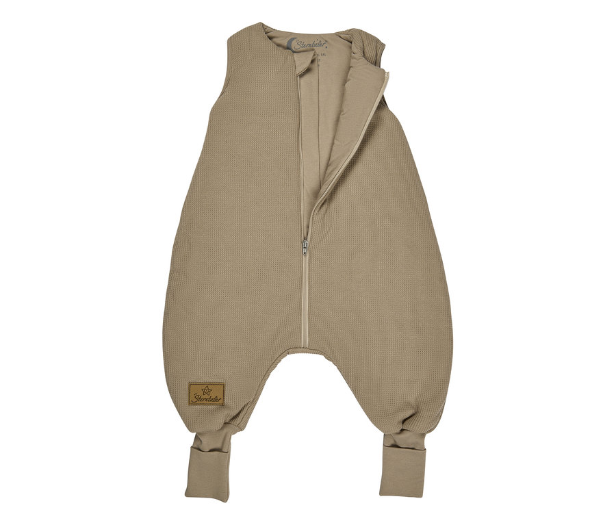 Gigoteuse bébé beige en tricot gaufré avec une fermeture éclair intégrale partiellement ouverte, sans manches et avec des poignets de pied intégrés.