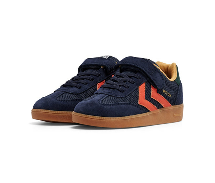 Une paire de baskets hummel® « VM78 CPH JR » bleu marine avec des chevrons orange, une semelle gomme et un scratch.