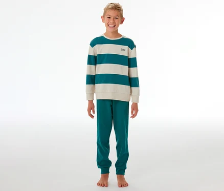 Garçon souriant debout dans un pyjama rayé turquoise et crème.