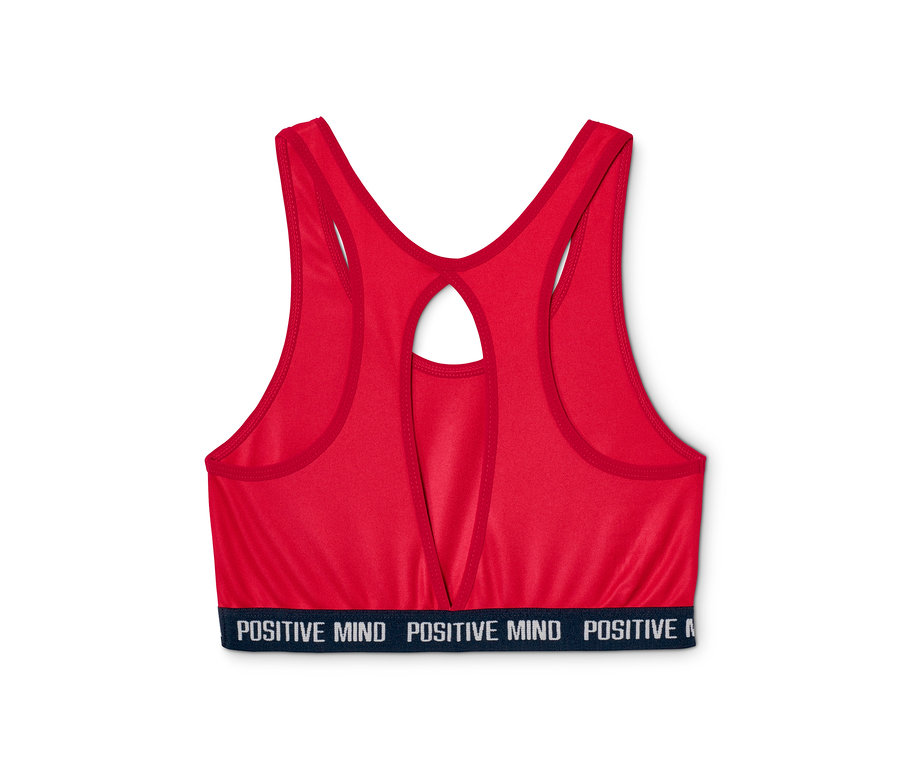 Gros plan d'une brassière de sport rouge d'un ensemble de 2 pièces avec l'inscription "POSITIVE MIND" sur la bande inférieure.