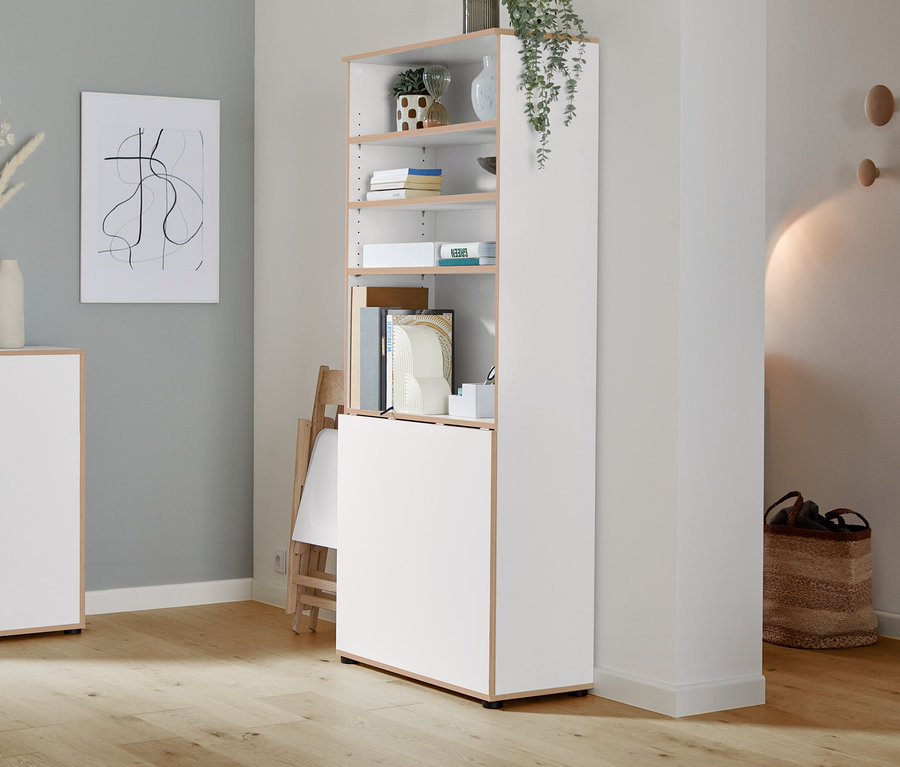 Une étagère blanche avec des portes est dans une pièce.