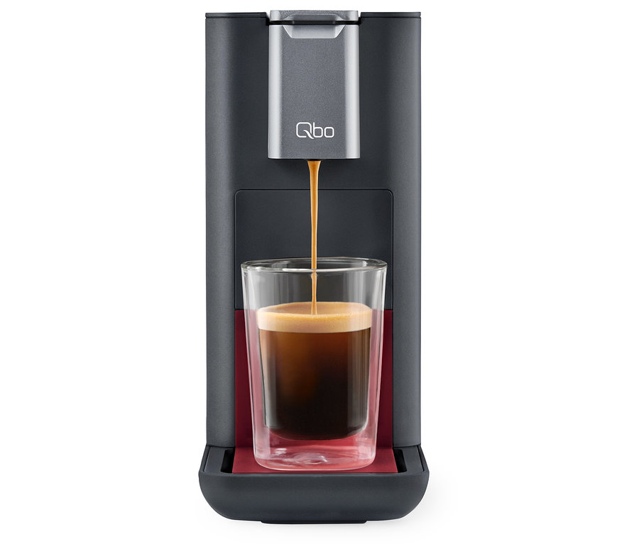 Le café coule d'une machine à café Qbo ESSENTIAL Dark Berry dans un verre.