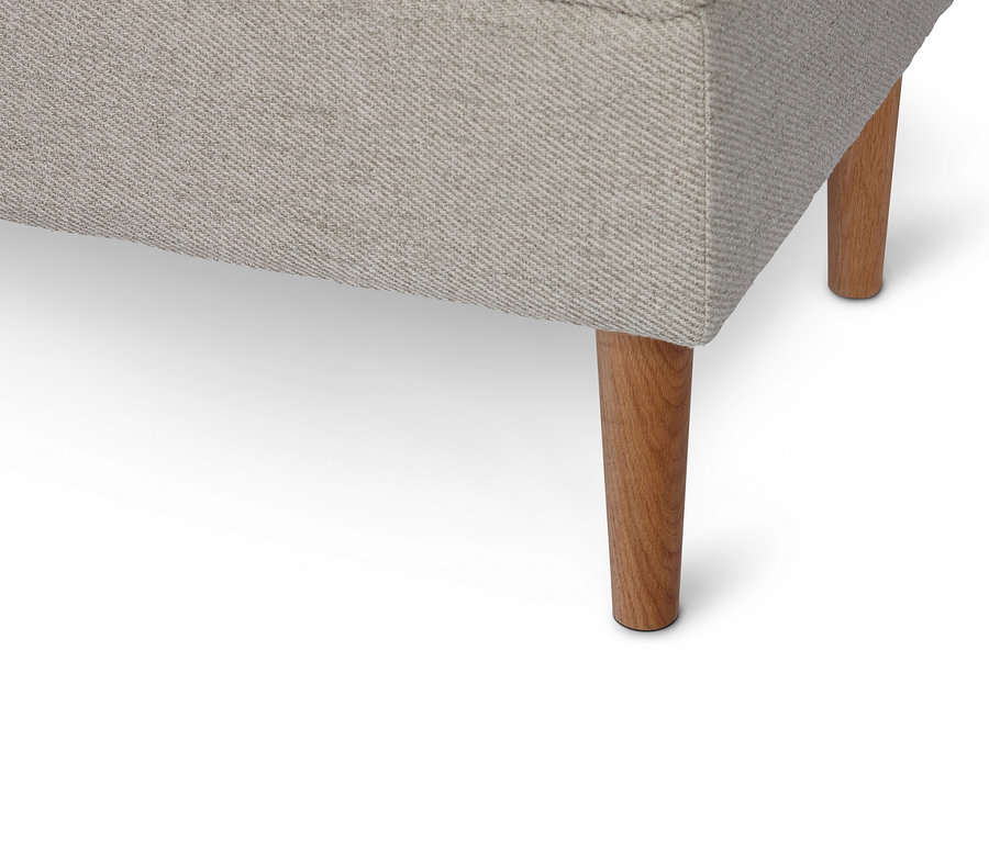 Détail d'un banc rembourré avec espace de rangement et pieds en bois.