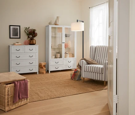 Intérieur avec un coffre tressé et un lampadaire arc avec abat-jour textile.