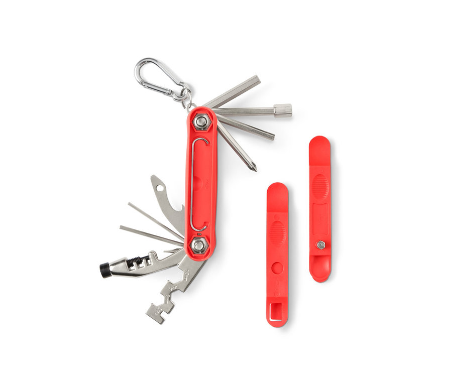 Un outil multifonction de vélo rouge avec différents accessoires sur un fond blanc.