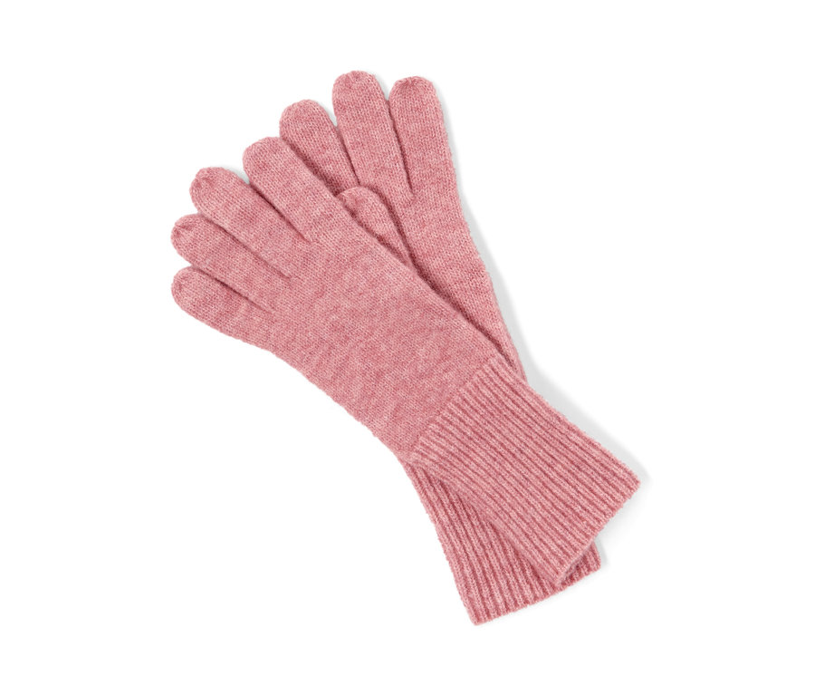 Une paire de gants en maille rose avec de la laine l'un sur l'autre.