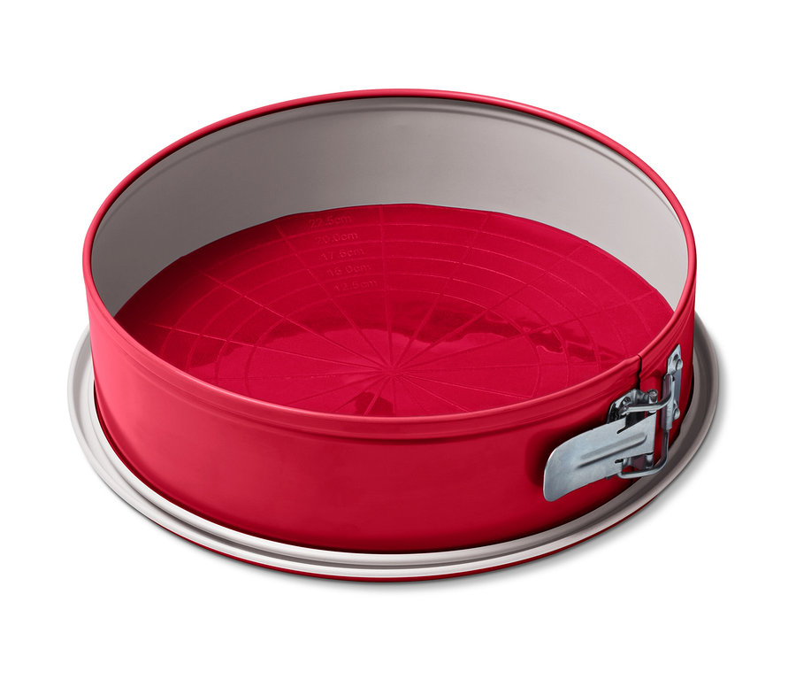Un tapis de cuisson réutilisable rouge à l'intérieur d'un moule à charnière rond.