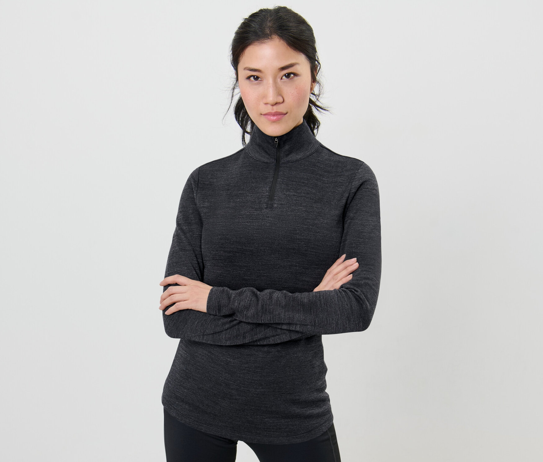 Femme posant les bras croisés portant un t-shirt technique avec de la laine certifiée RWS.