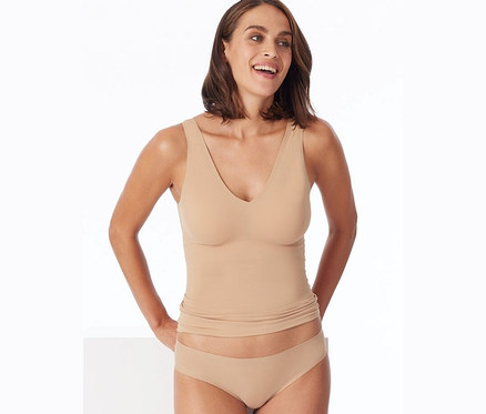 Une femme porte un débardeur et un slip Rio invisible SCHIESSER en coton, beige.