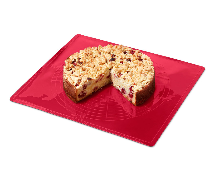 Un gâteau crumble coupé sur un tapis de cuisson réutilisable rouge.