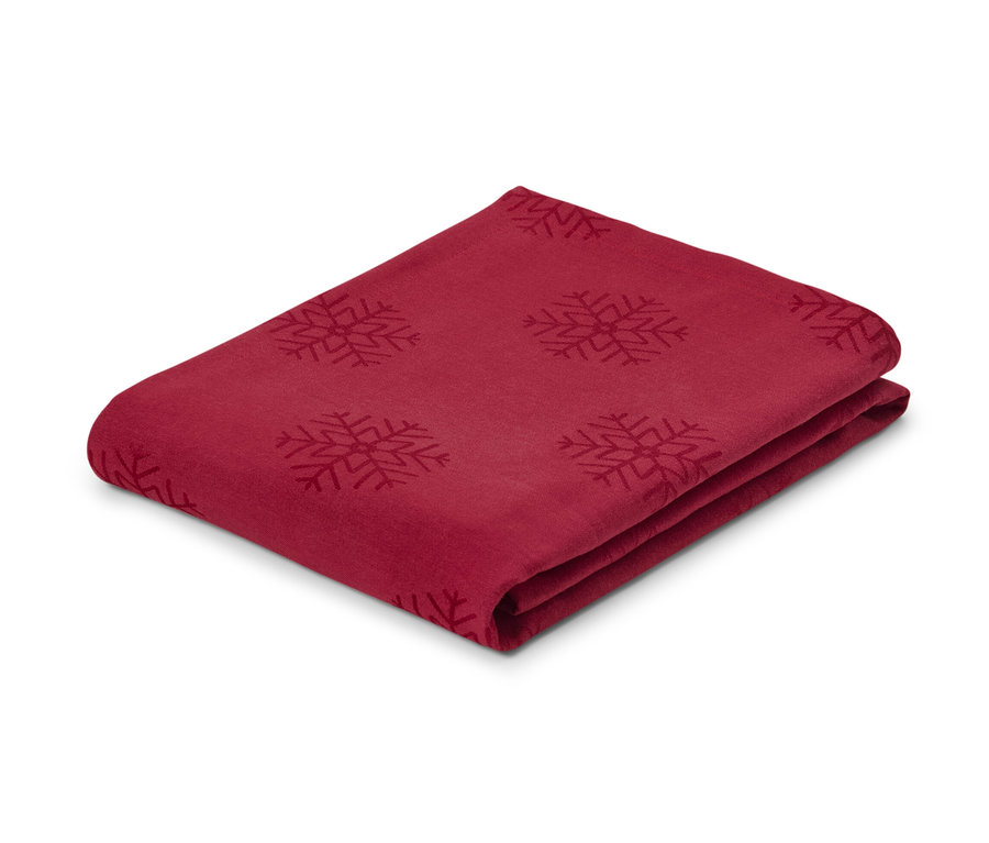 Nappe en jacquard rouge pliée avec motif de flocons de neige, en taille normale et grande taille.