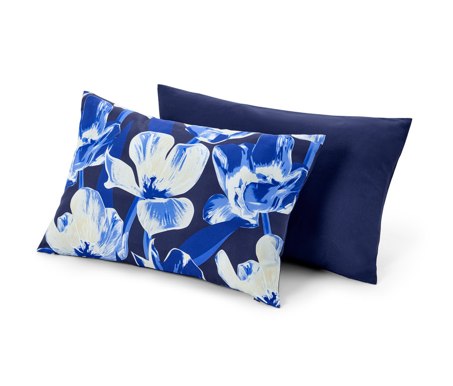 Deux housses de coussin décoratif : une à motif floral et l’autre bleu marine.