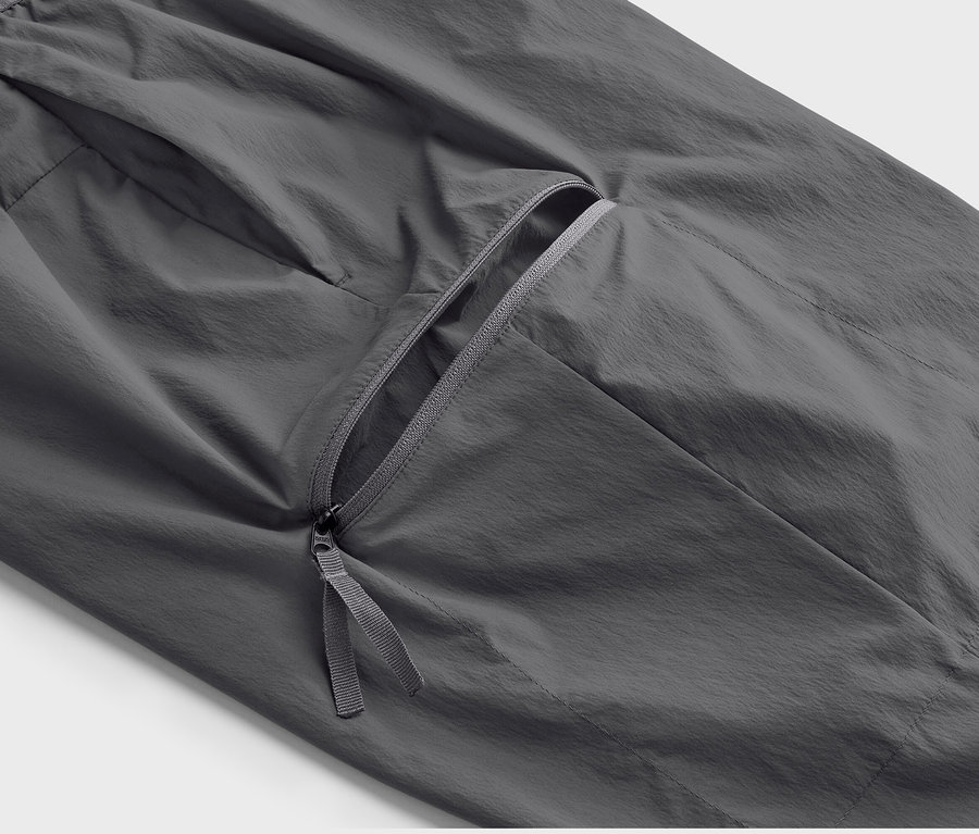 Gros plan sur un pantalon fonctionnel léger gris avec une poche zippée.