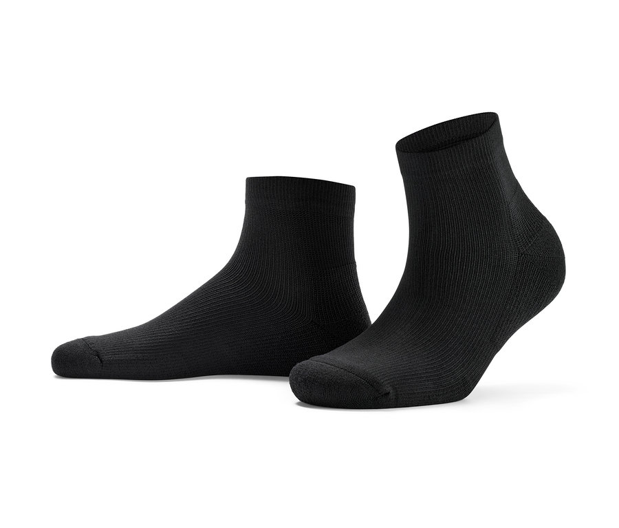 Deux paires de chaussettes de sport courtes sont posées sur le sol.