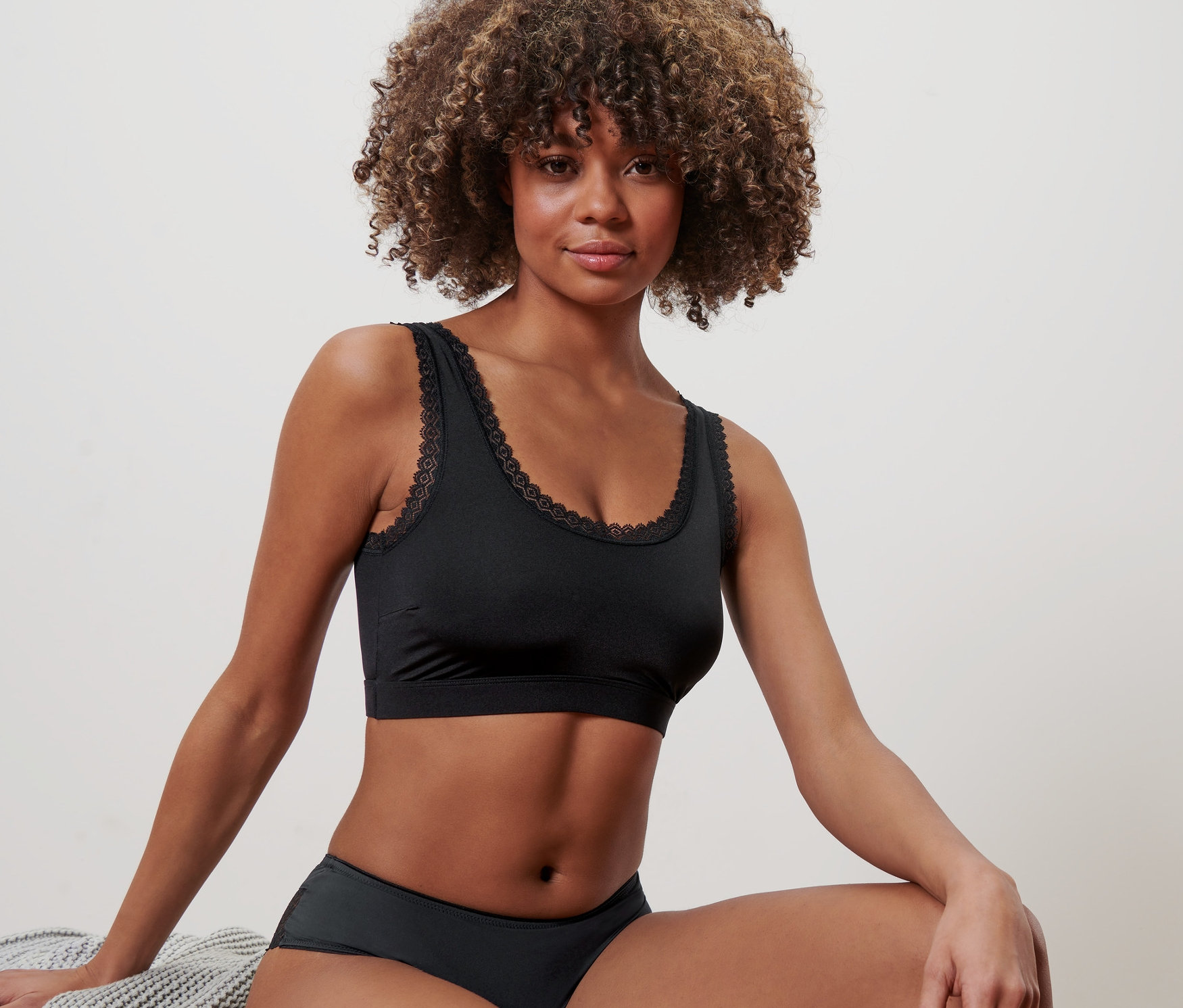 Femme assise portant un bustier noir.