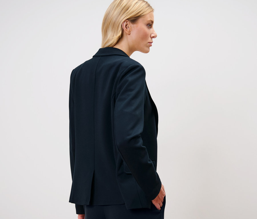Blonde portant un blazer en jersey.