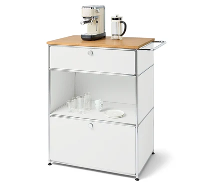 Machine à café et presse française sur une commode blanche avec tiroirs et une étagère avec des verres et une assiette.