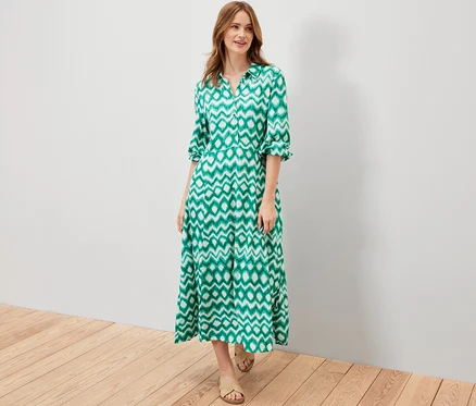 Femme posant dans une robe chemise imprimée verte.