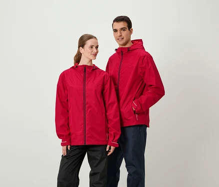 Deux personnes en vestes rouges et pantalons sombres se tenant côte à côte.