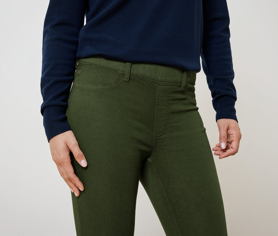 Gros plan d'une femme portant un pantalon vert olive et un pull bleu marine.
