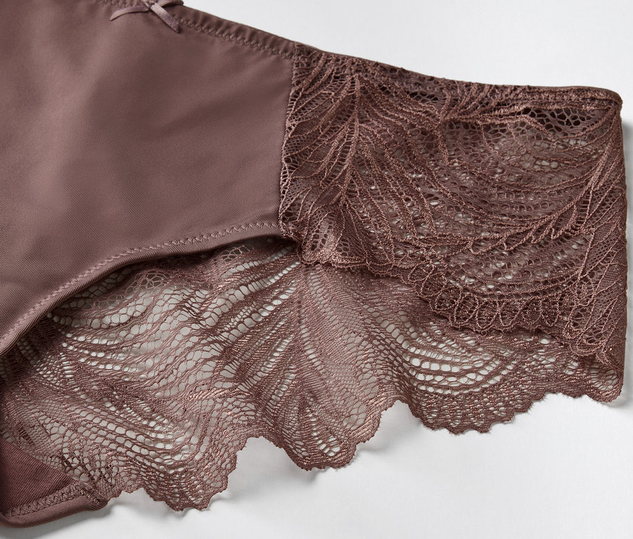 Détail d'une culotte marron avec de la dentelle florale.
