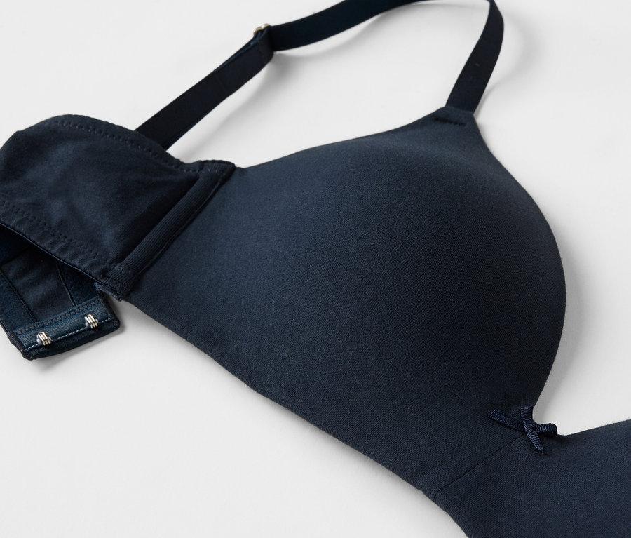 Gros plan d'un soutien-gorge bleu marine avec bretelles réglables et fermeture à agrafes.