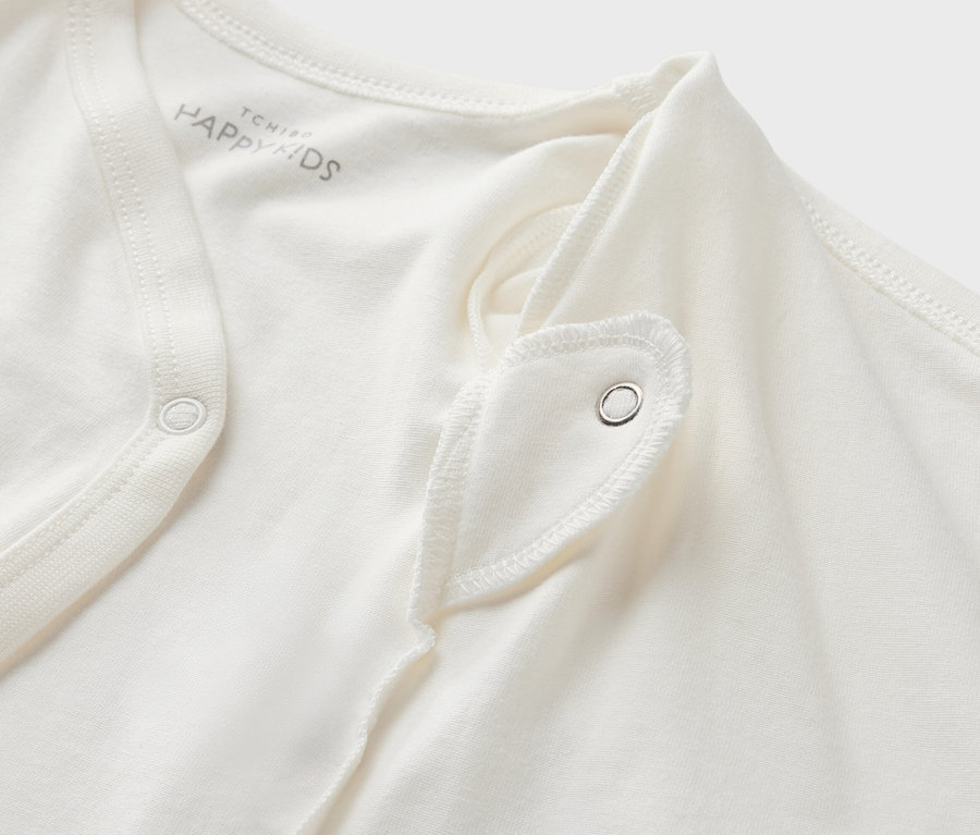 Gros plan sur un body évolutif blanc pour bébé avec bouton-pression.