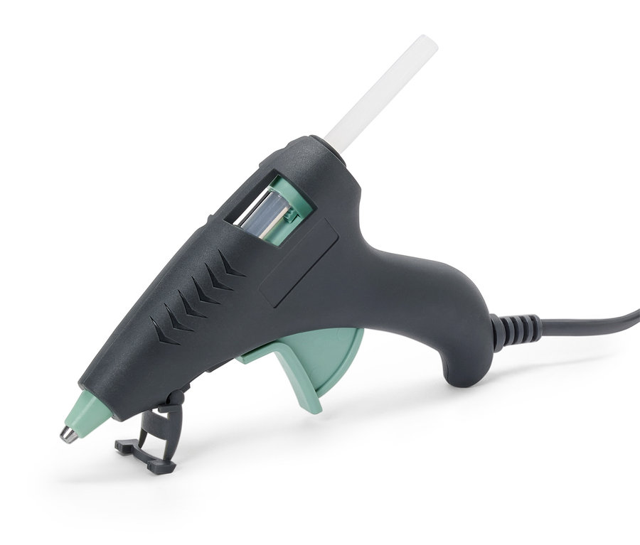 Un pistolet à colle gris avec un bâton de colle transparent.